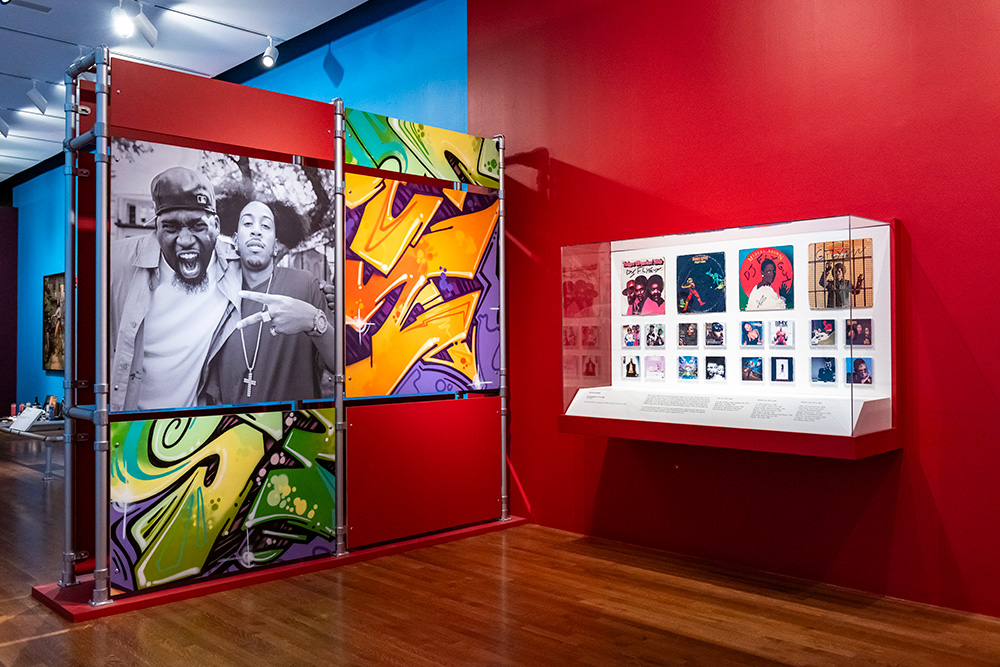 A red wall featuring a photo of David Banner and green and orange graffiti