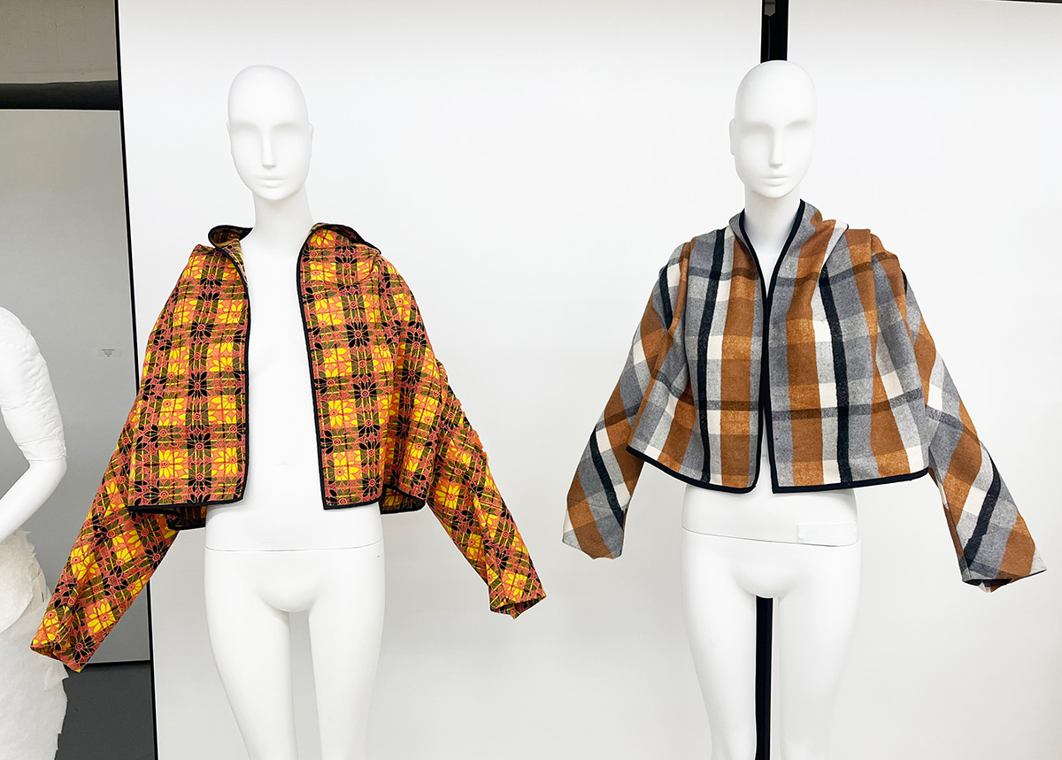 Two hooded jackets on plain white mannequins. The hoods are down.