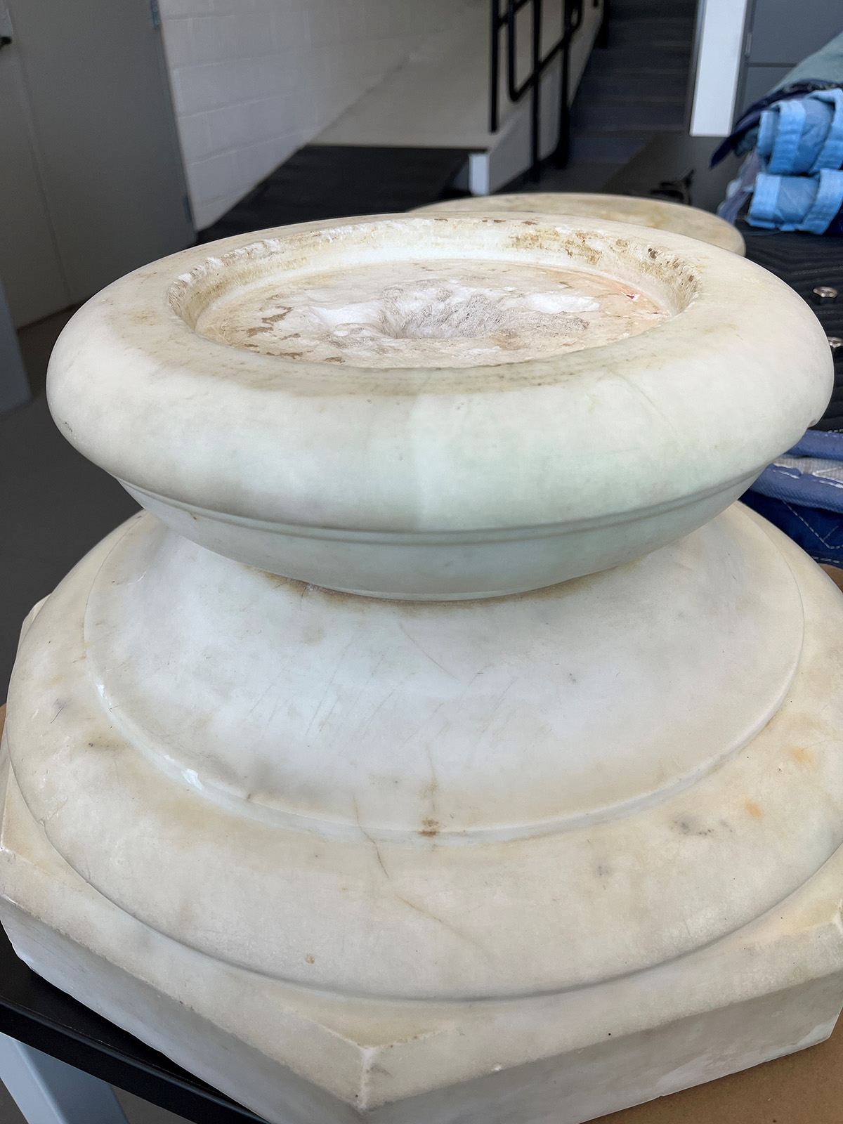 A large marble pedestal. The pedestal is scratched and dirty.