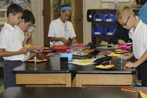 a group of school kids work on arts and crafts