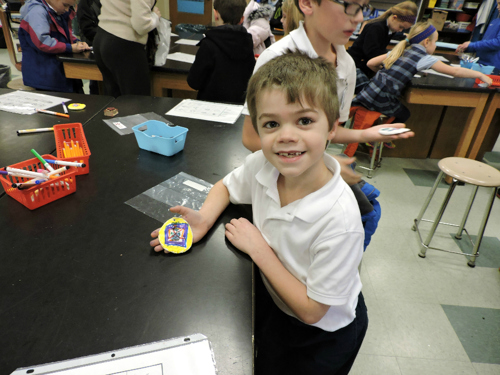 a young boy shows off his creation