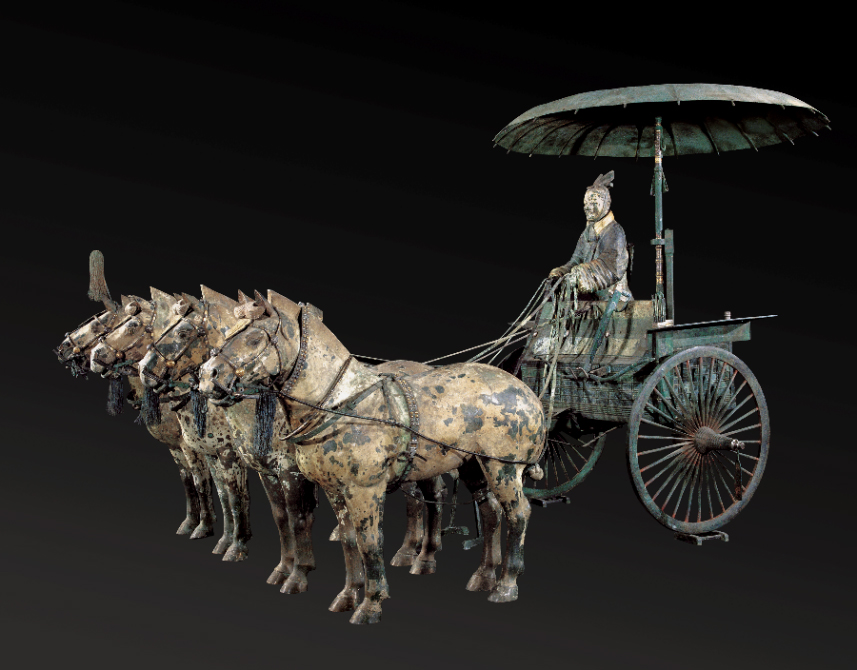 bronze statue of a man riding a chariot drawn by four horses 