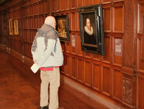 Dad inspecting a painting in a gallery