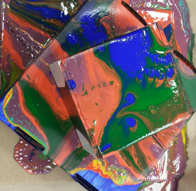 two stacked boxes with a multitude of paints poured over top