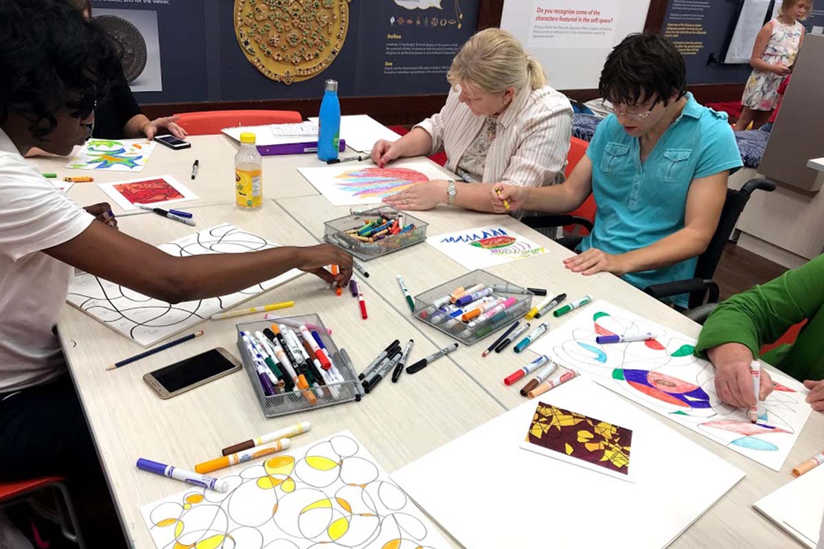 visitors sit at a table enjoying arts and crafts