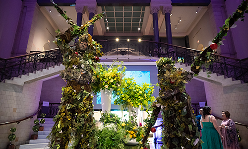 Performers costumed as trees pose in the Great Hall