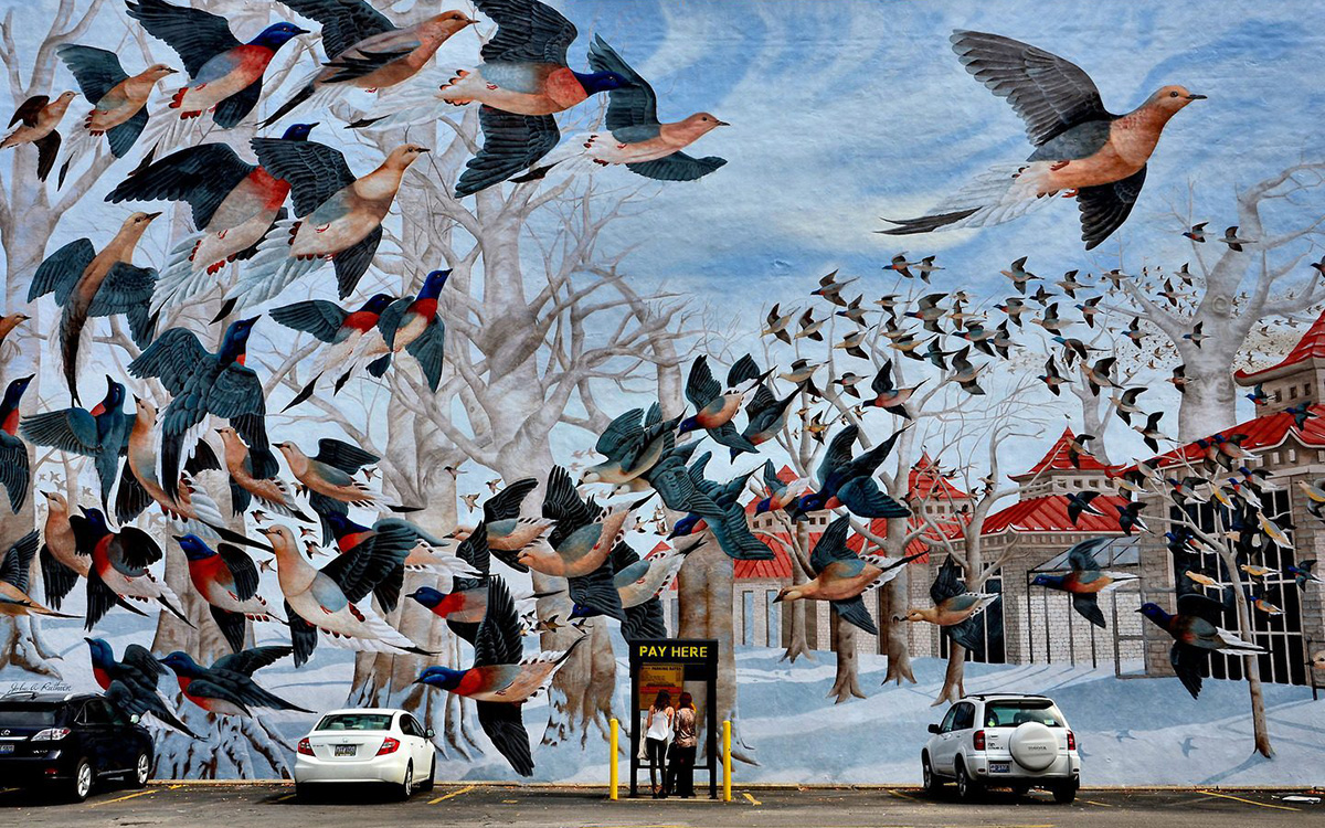 ALTERNATE IMAGE TEXT: Large outdoor mural on the side of building facing a parking lot; mural depicts a flock of birds and a line of Chinese-style pavilions.