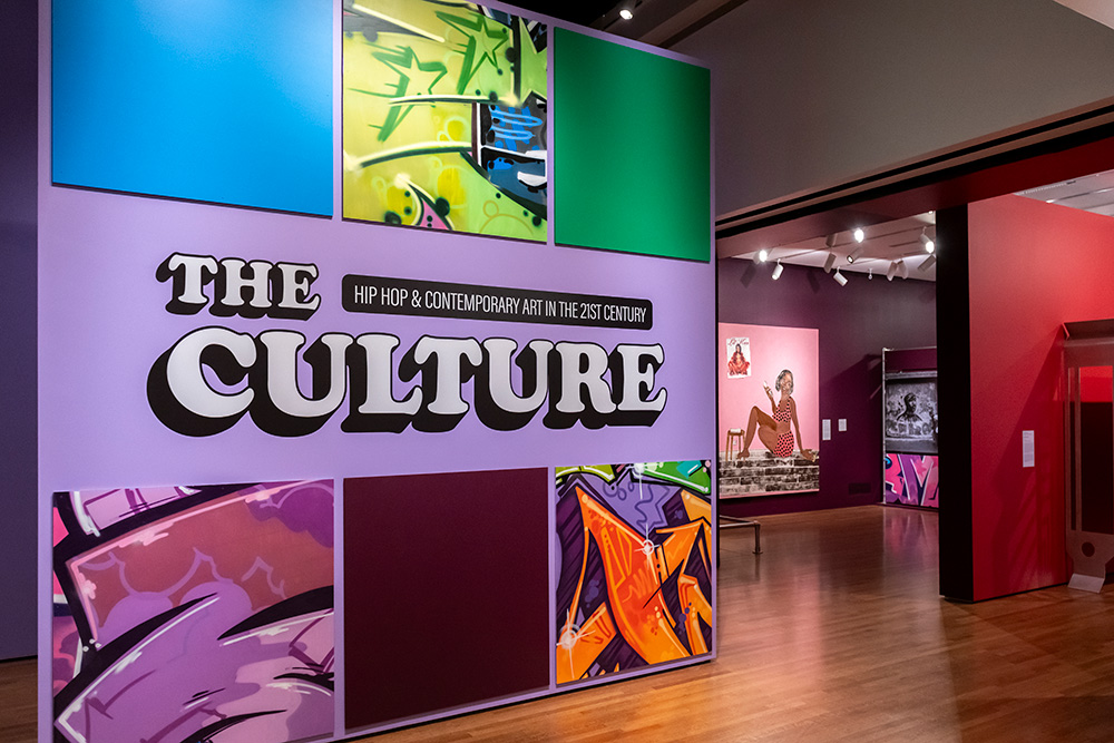 The title wall of The Culture, featuring six colorful squares. Three of the squares include jagged graffiti