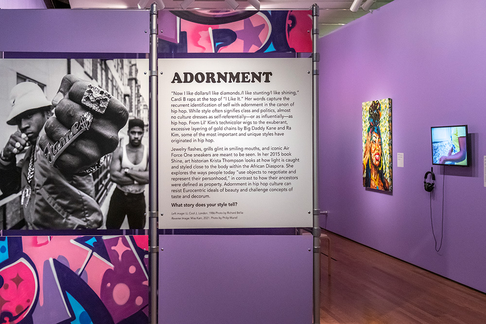 A purple wall with a large photo of LL Cool J and pink and purple graffiti