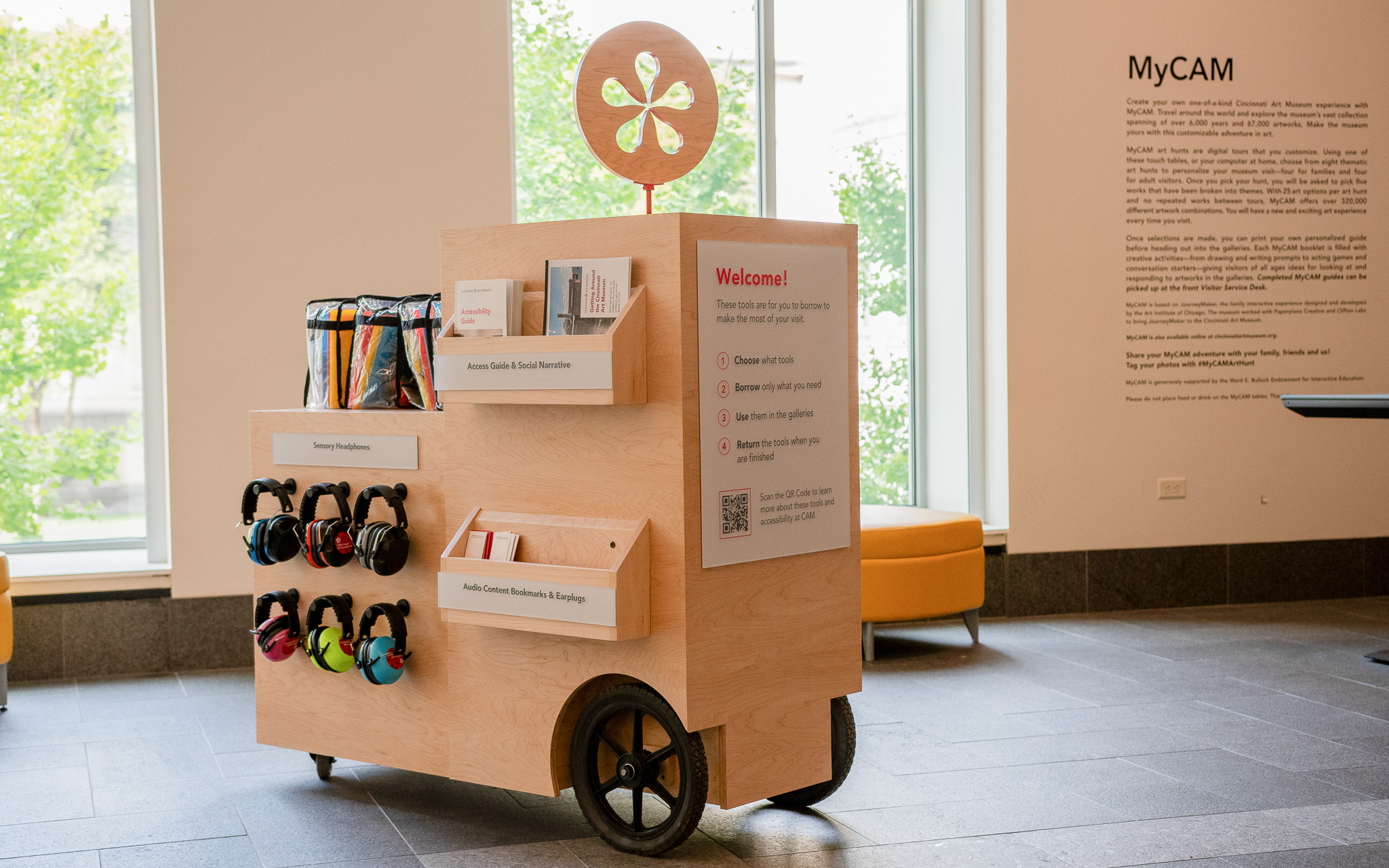A wooden cart with accessibility resources available to visitors.