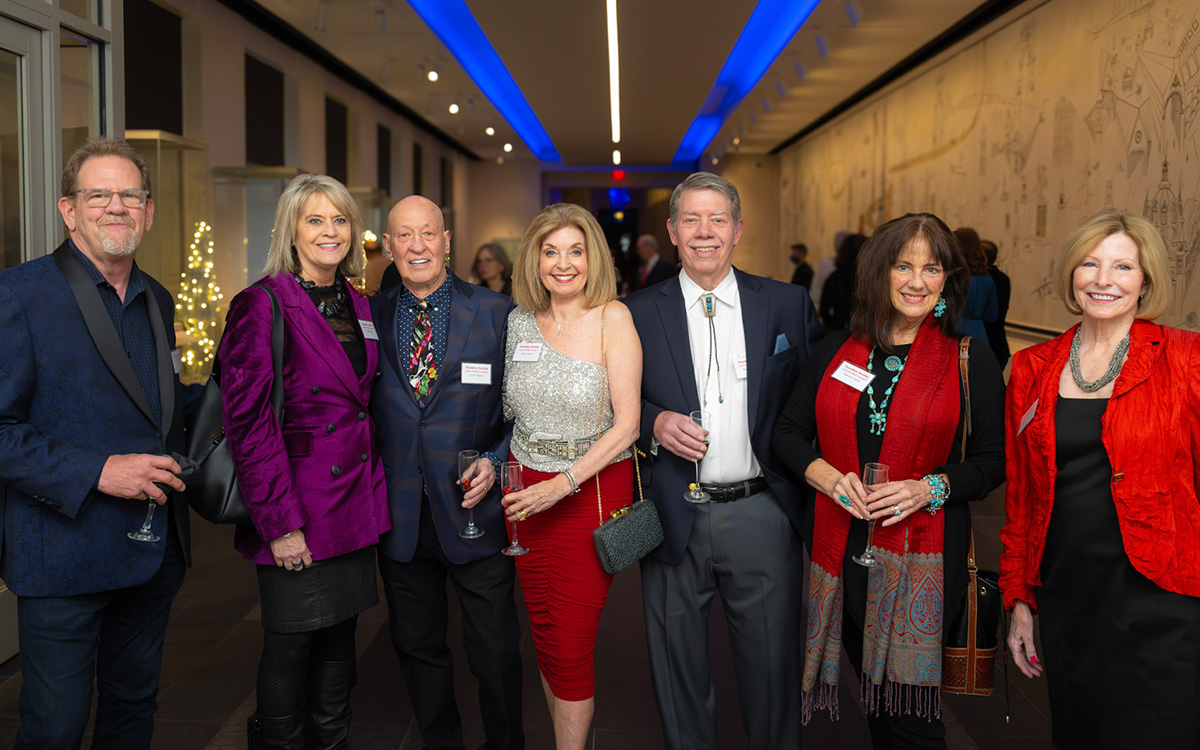 A group of nicely-dressed white people smile for the camera