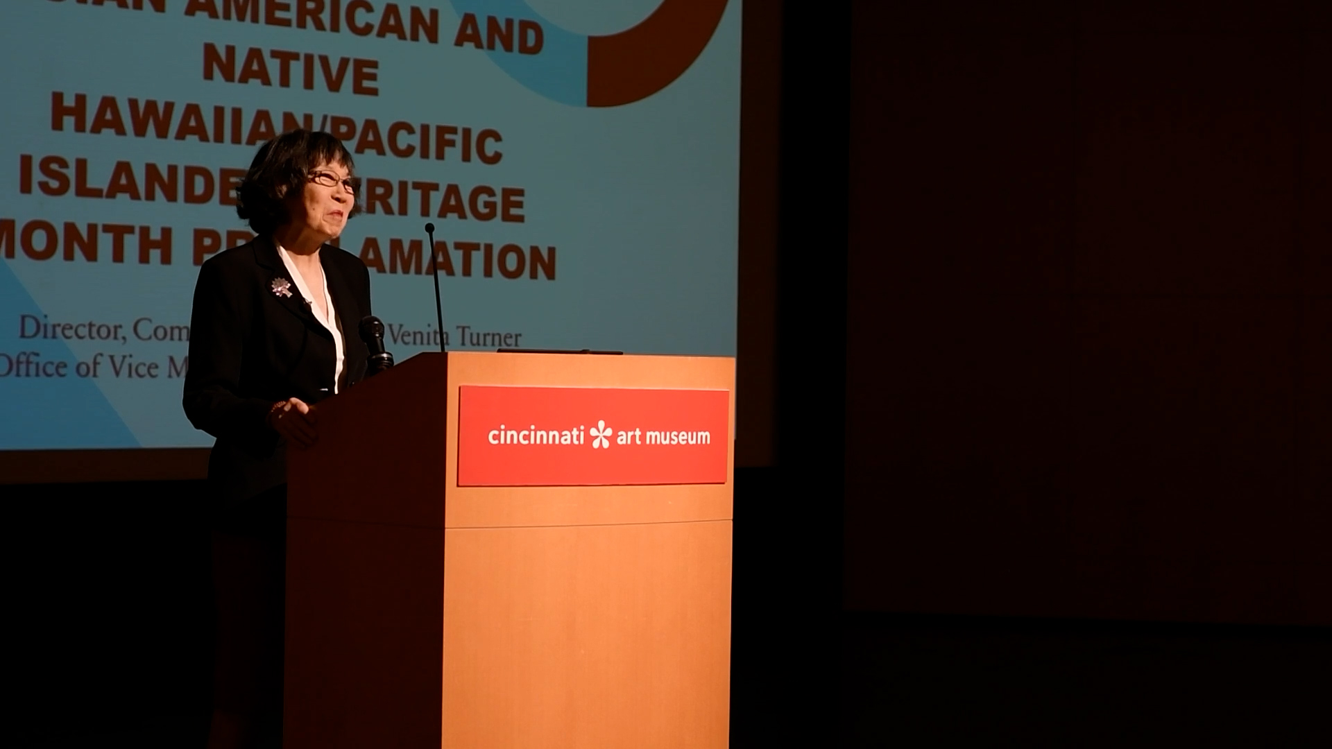 Dr. Hou-mei Sung smiles while standing at a podium on a stage