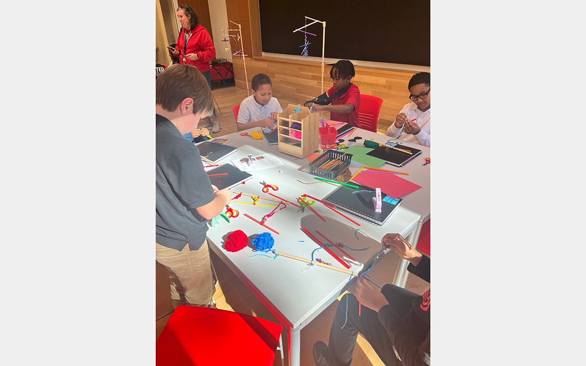 Kids making art on a table in a classroom