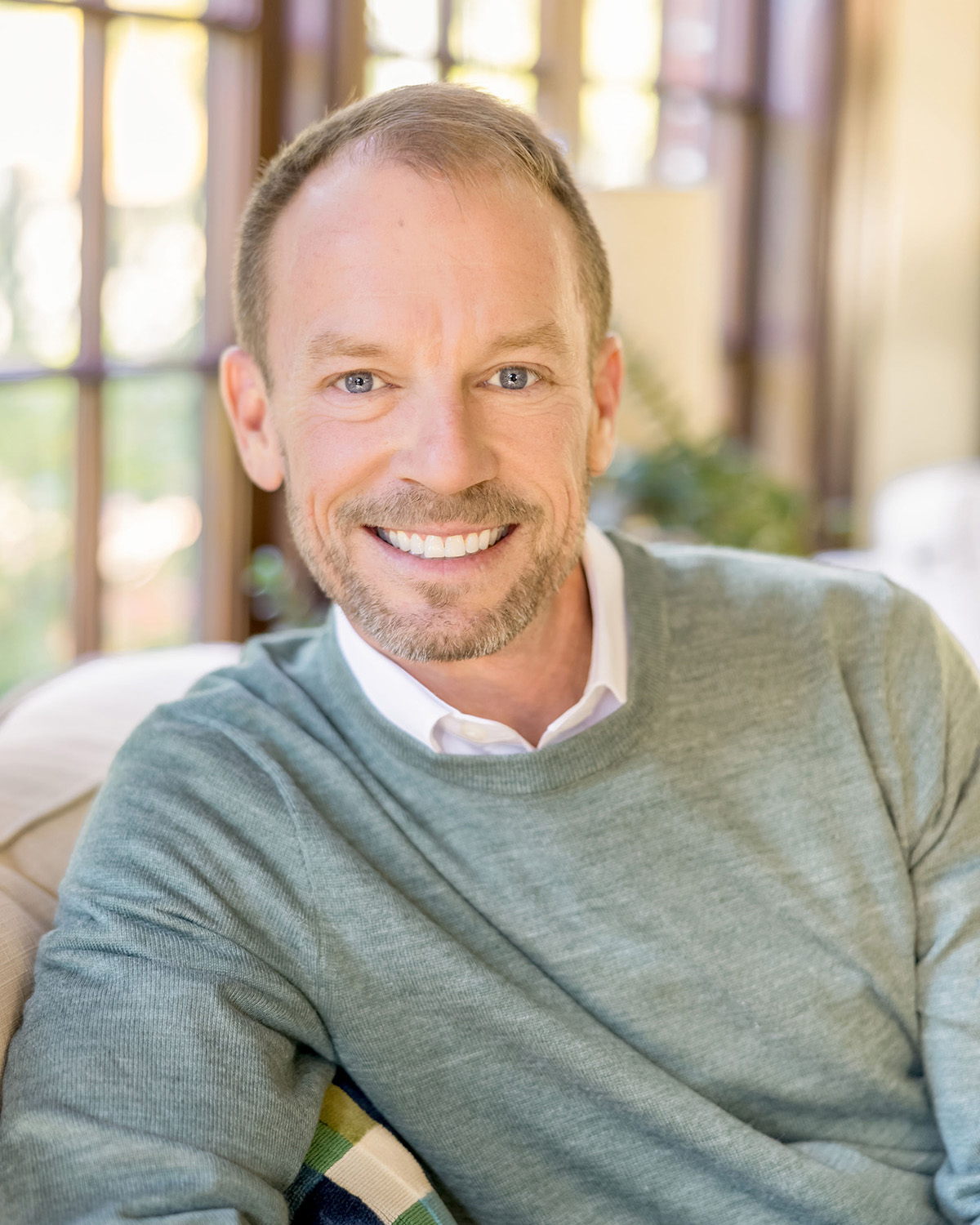 A white man with light brown hair in a gray shirt