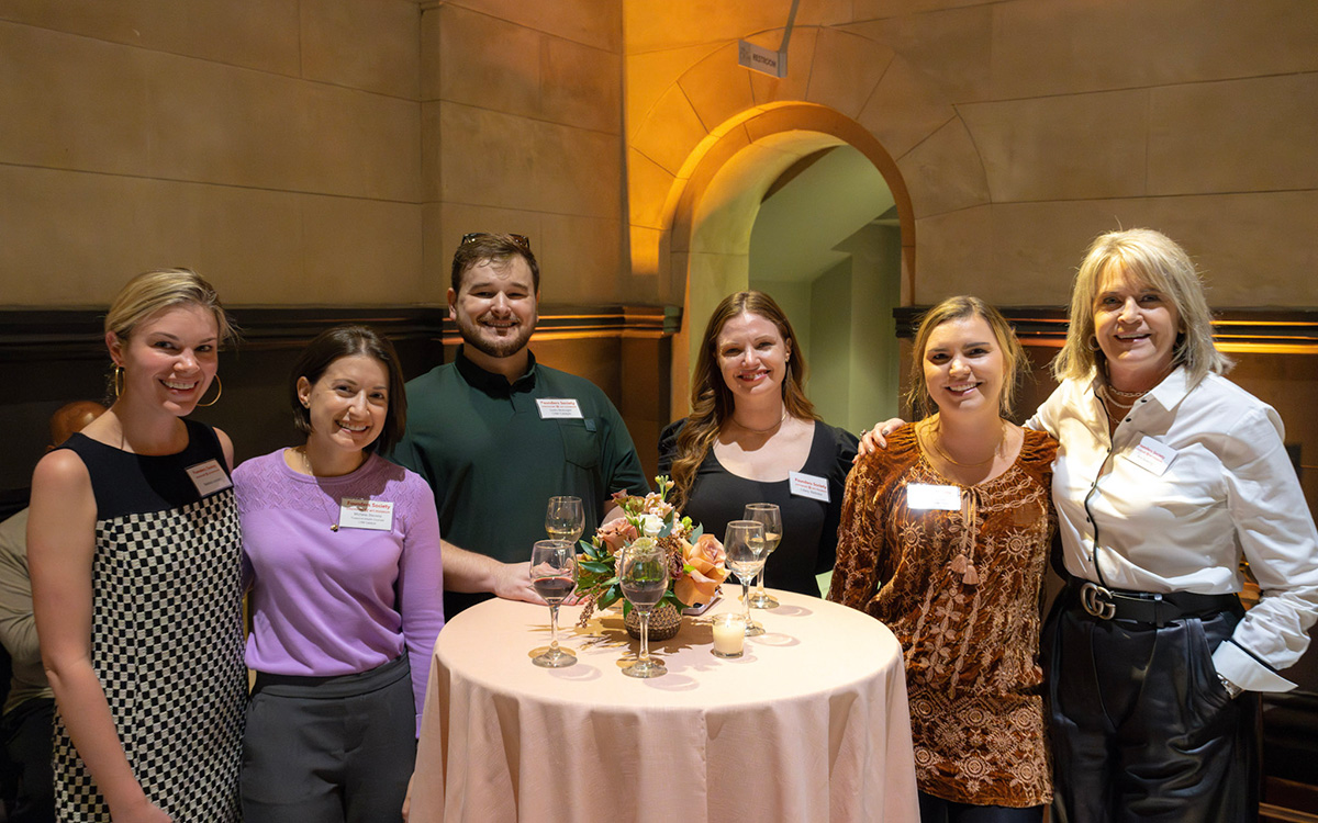 A group of young white Founders gather around a cocktail table