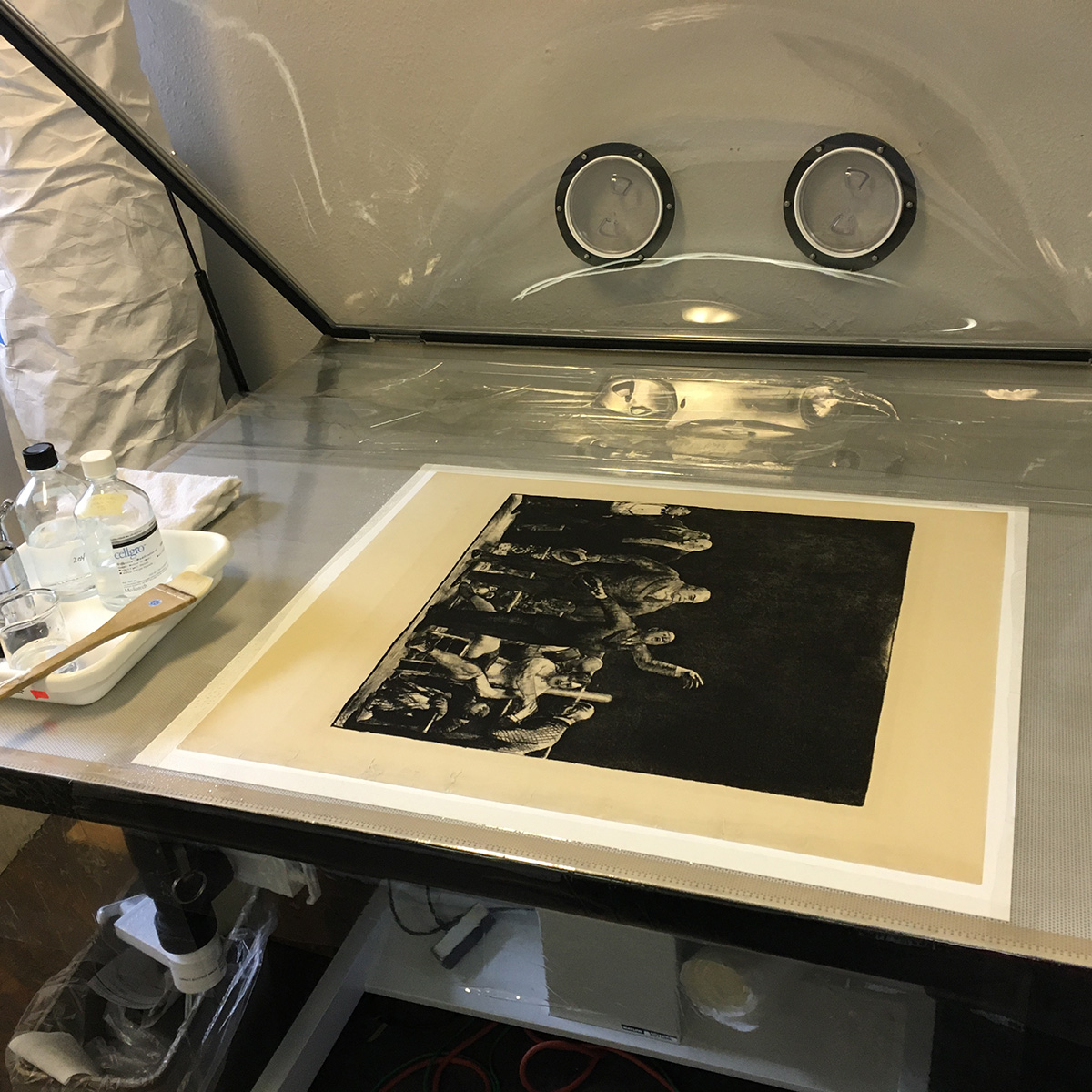The yellowed print sits on a table with a clear, raised lid