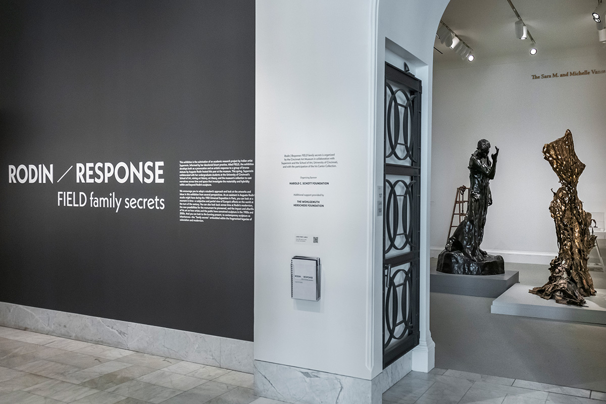 A photo of the Rodin | Response title wall and two of the featured scupltures