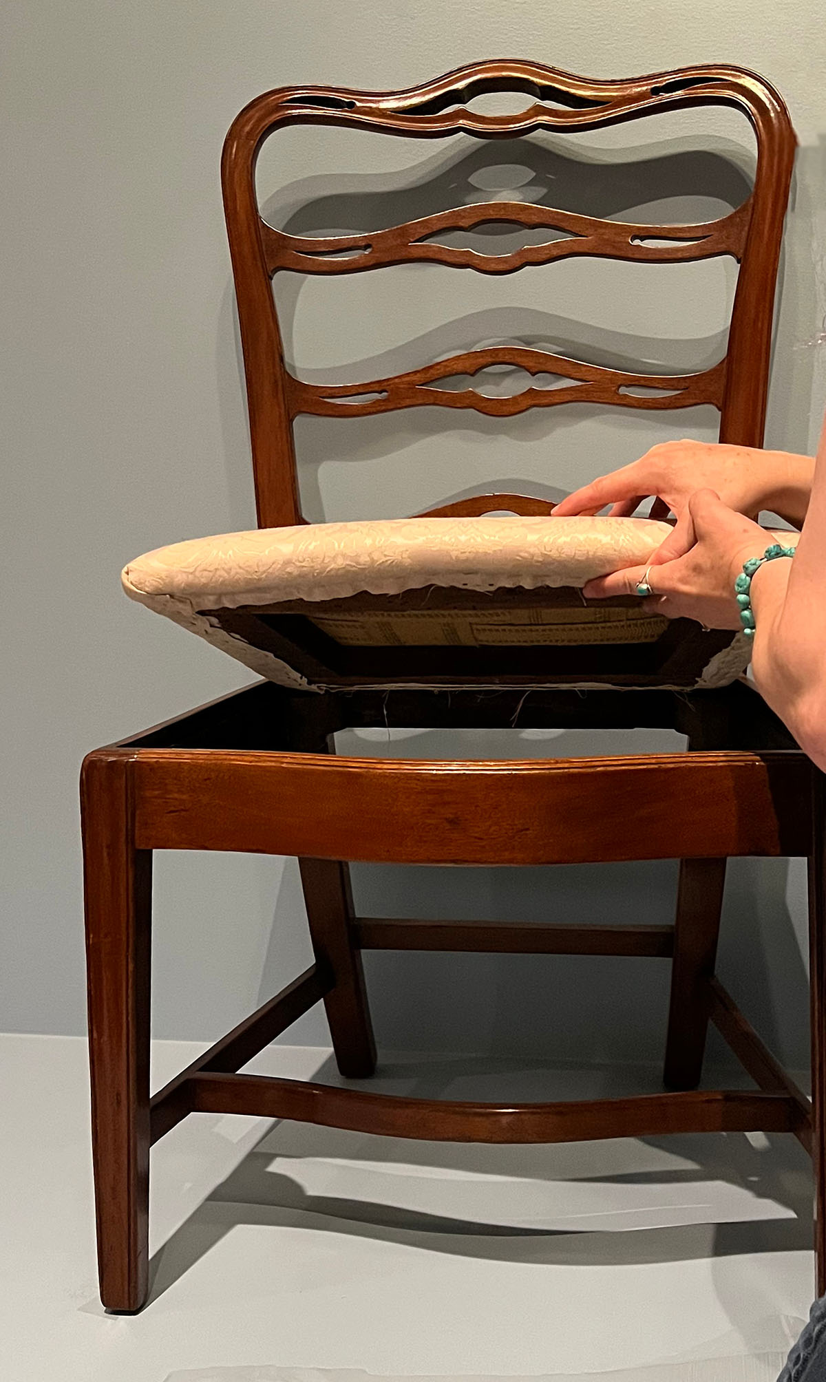 Lowering the reupholstered seat onto the chair frame