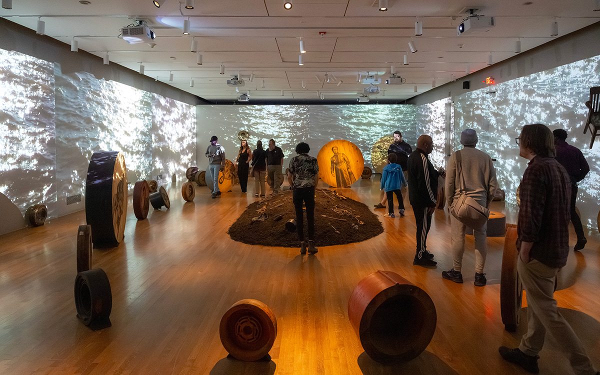 Many visitors explore a massive, immersive installation on a gallery